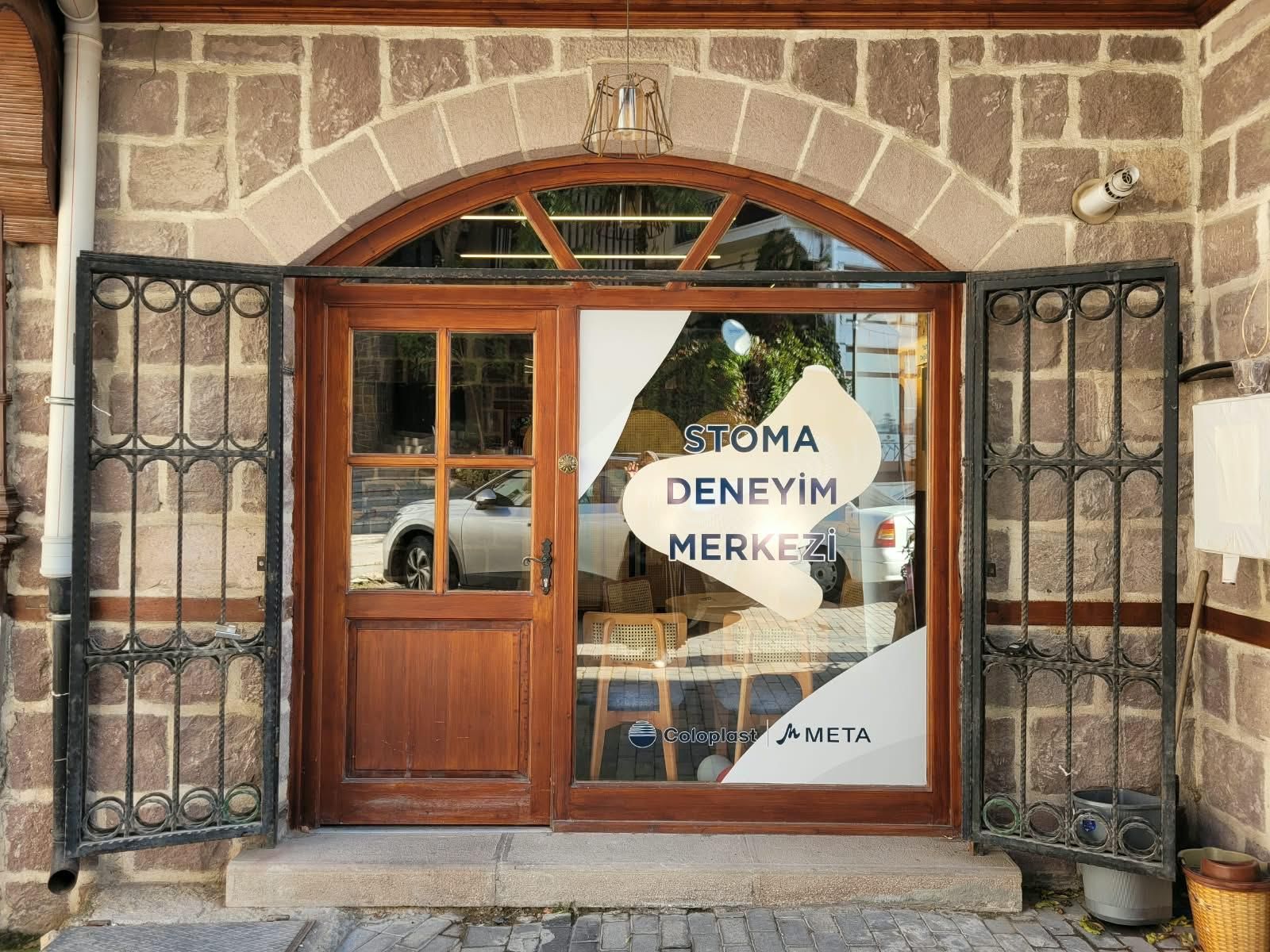 Stoma Deneyim Merkezi girişi: kemerli ahşap kapı ve cam üzerinde merkezin adı